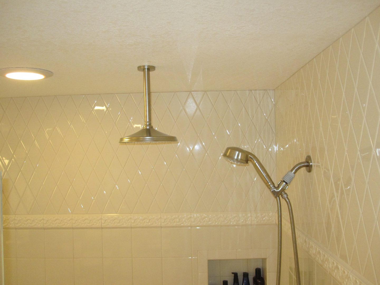 Ceiling-mounted showerhead in tiled bathroom