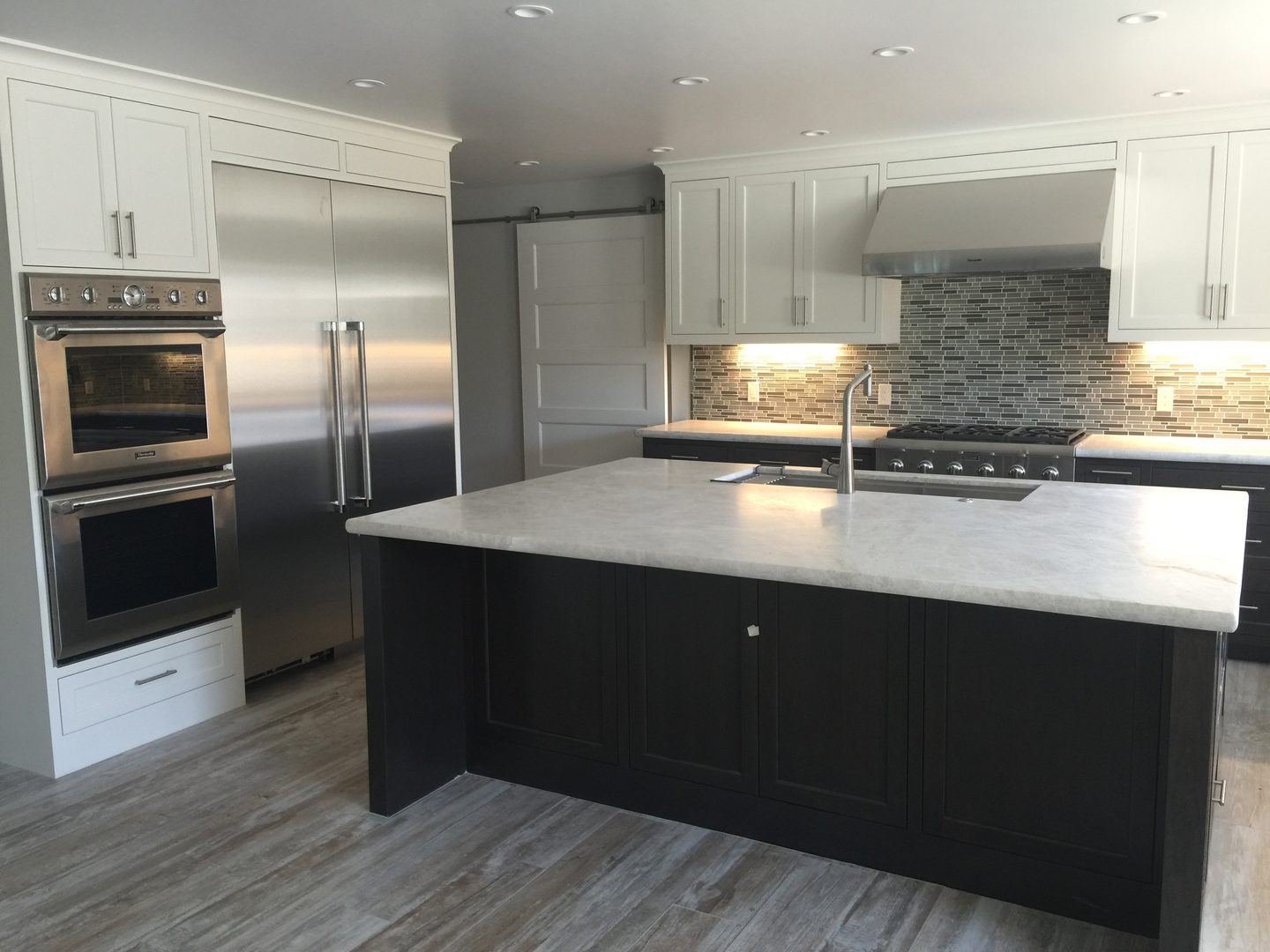 Modern kitchen with island and stainless appliances.