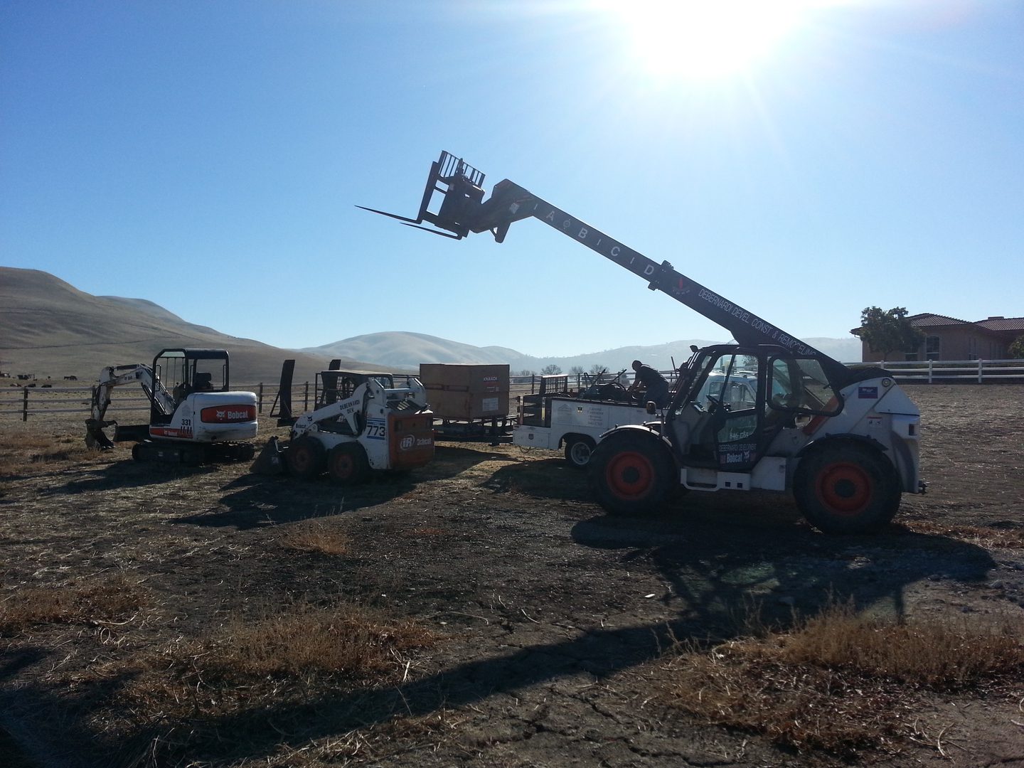 Forklift and loaders on dirt ground
