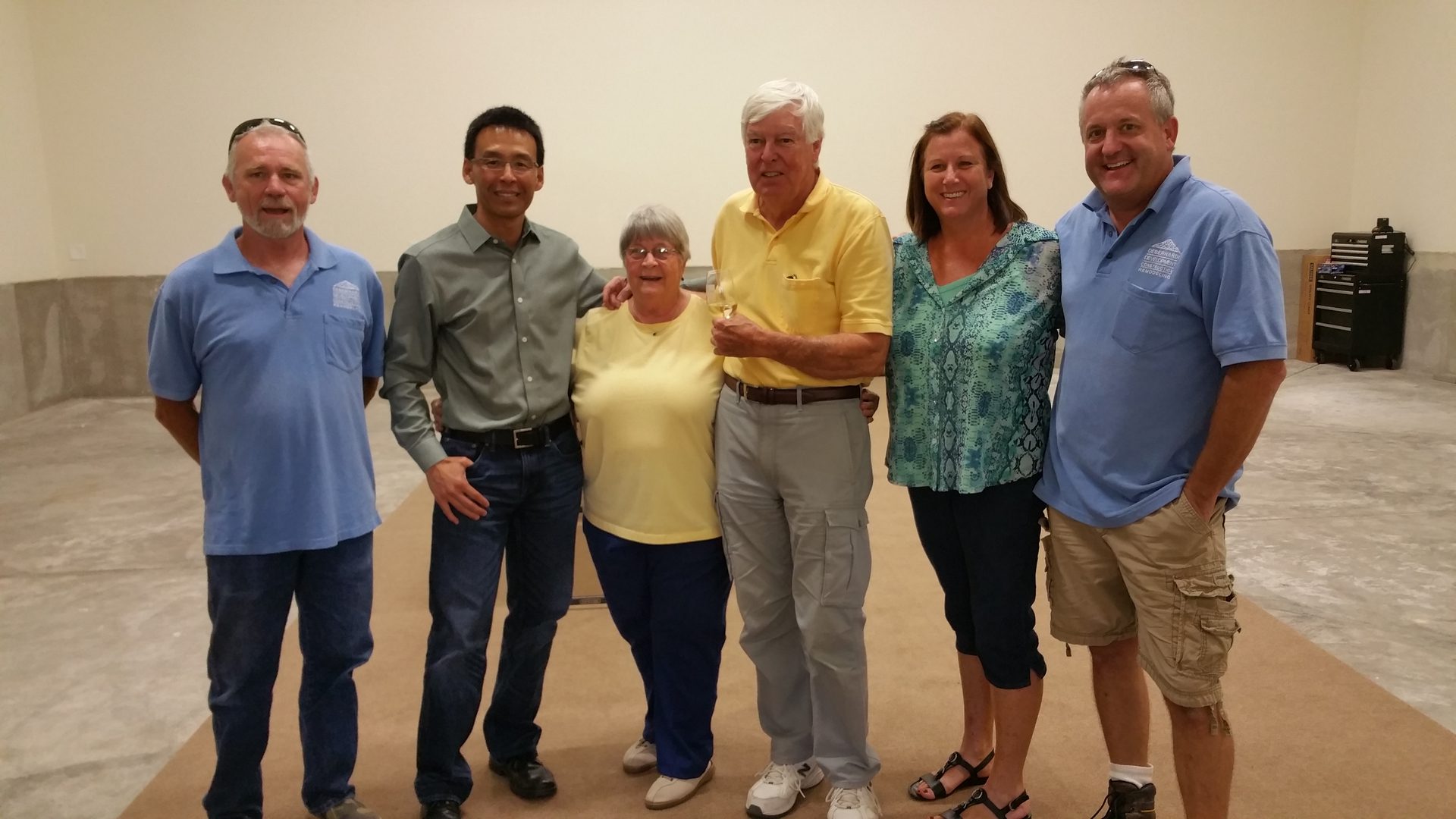 Group of six people standing together indoors.