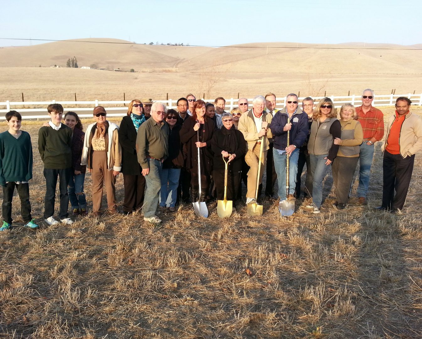 Group with shovels in open field