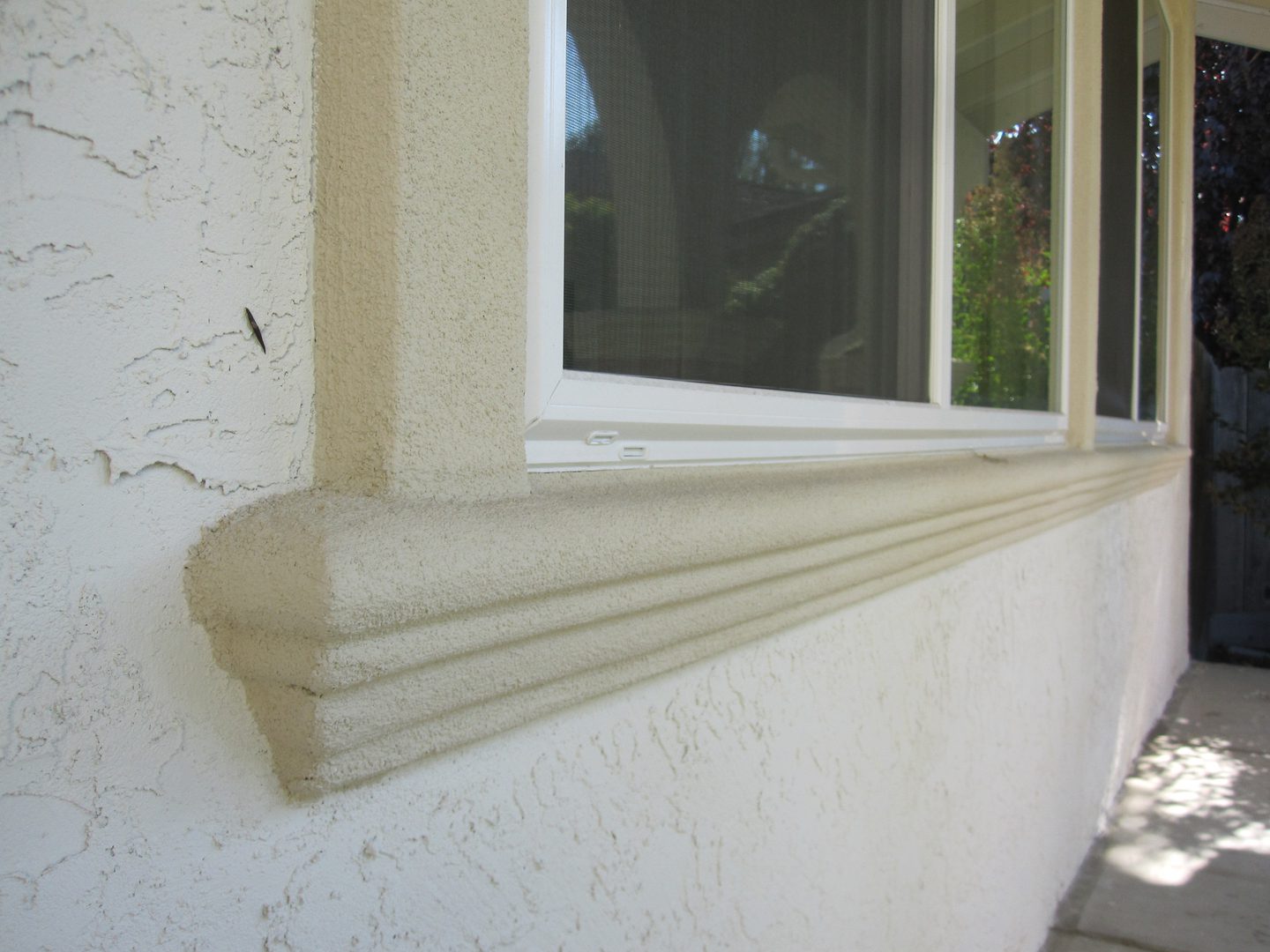 Close-up of textured stucco window ledge